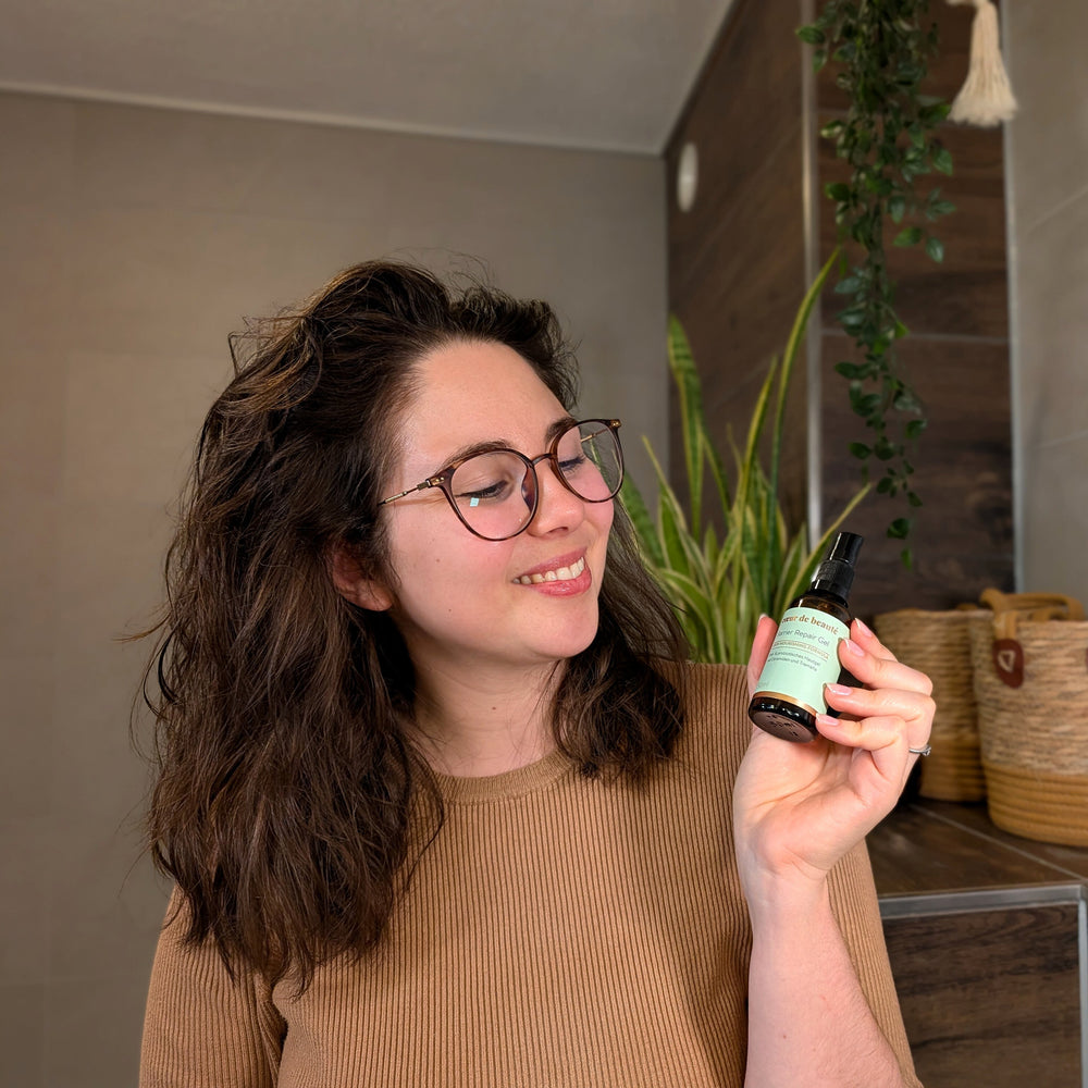 lächelnde Frau hält Barrier Repair Gel von coeur de beautè in der Hand. ohne Duftstoffe für sensible Haut. Prä- und Probiotisch mit Ceramiden. ölfreies Hautgel