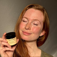 Frau mit lächeln und geschlossenen Augen hält Mikrobiom Creme in der Hand für sensible Haut von coeur de beaute aus Berlin