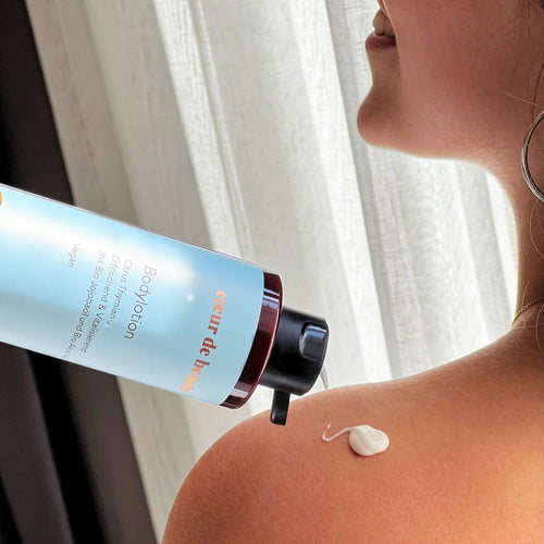 Frau hält die Citrus Bodylotion von cœur de beauté in der Hand.